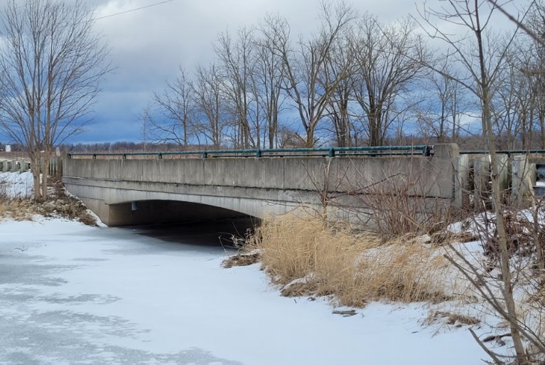 Concrete road bridge over a frozen waterway, slated for rehabilitation